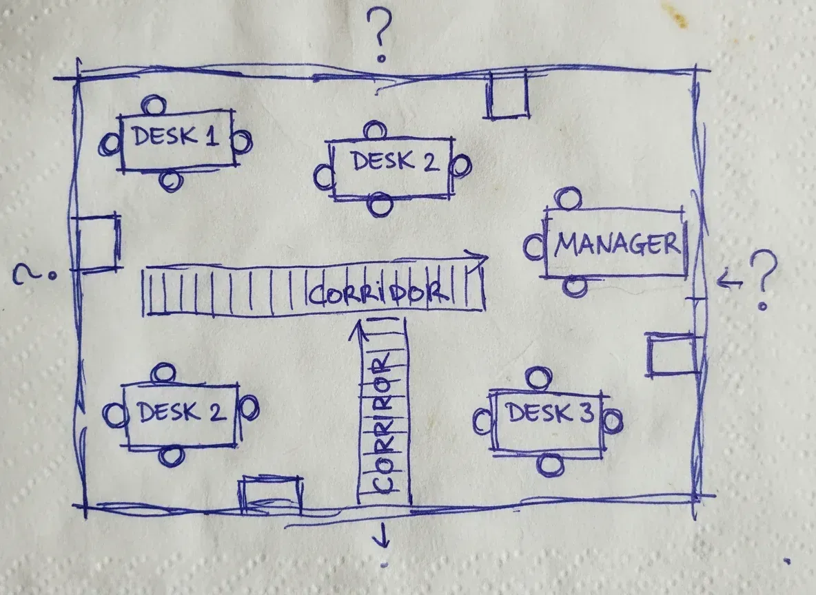 Hand-drawn office layout sketched in blue pen on a paper napkin